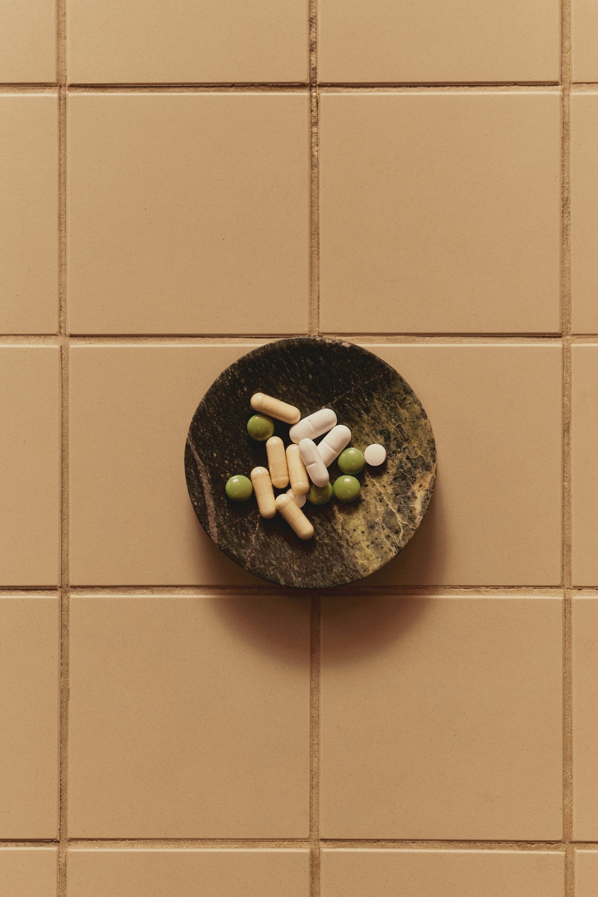 A small dish of capsules on a tiled counter